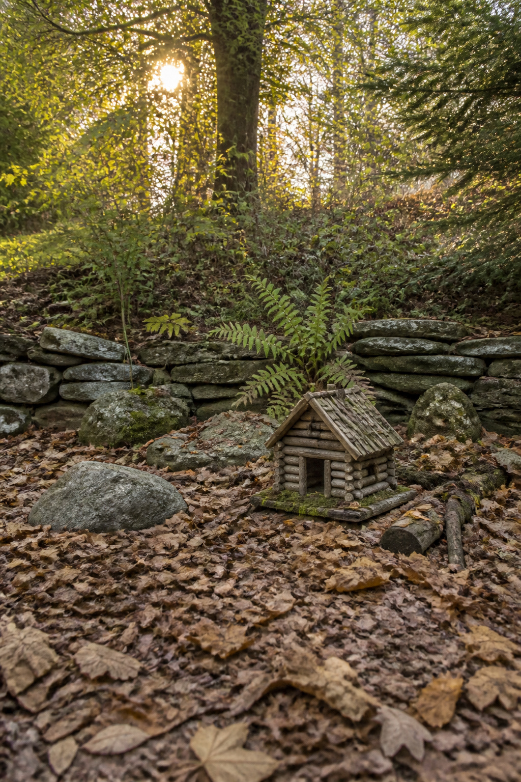 DIY Garden Fairy House: 20 Ways to Build One 3 Log fairy cabin made from branches and logs in a garden.