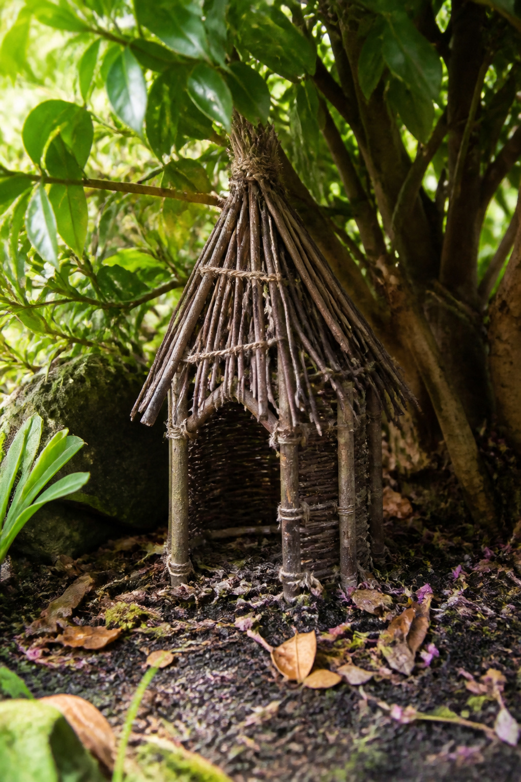 DIY Garden Fairy House: 20 Ways to Build One 4 Twig fairy house crafted from pencil-thick branches under a shrub.