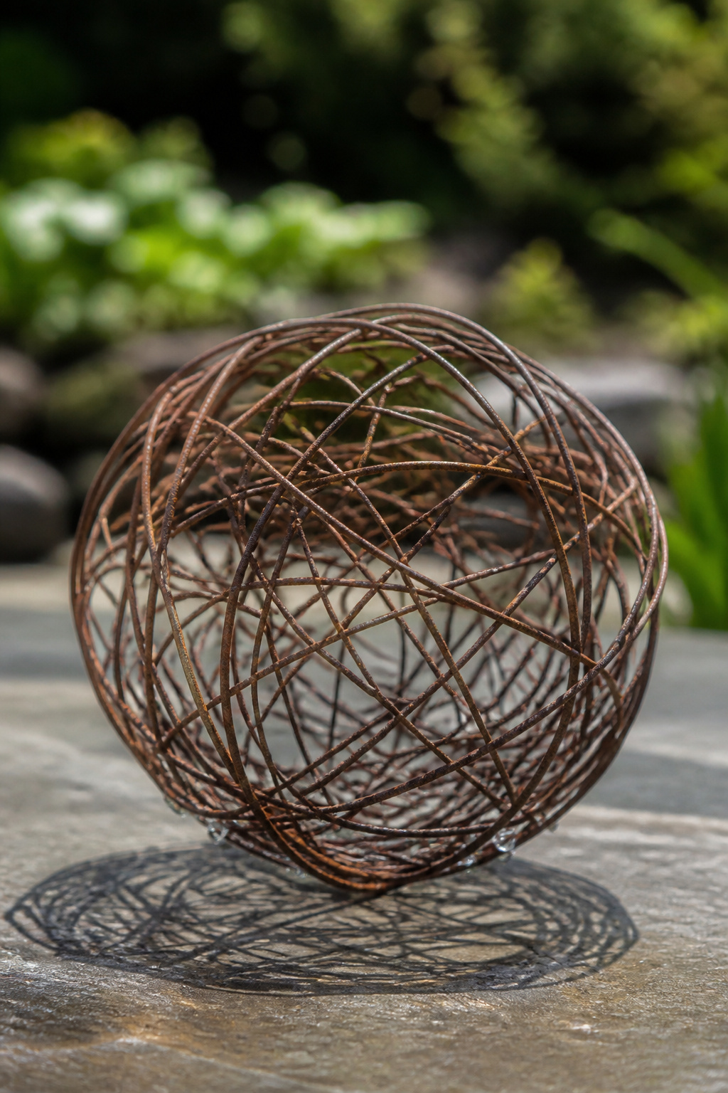 Open wire balls made from old fencing create shadow patterns on grass.